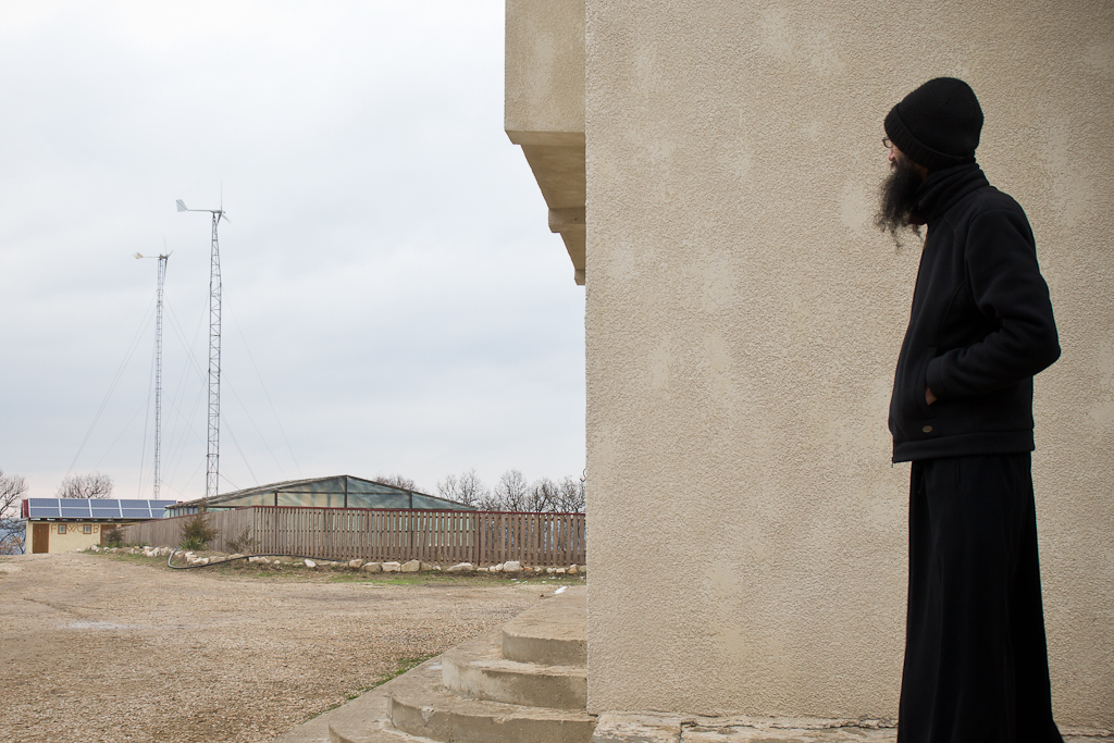 A monk at the Casian Monastery in Romania looks at the two wind turbines that are installed as part of the renewable energy system.