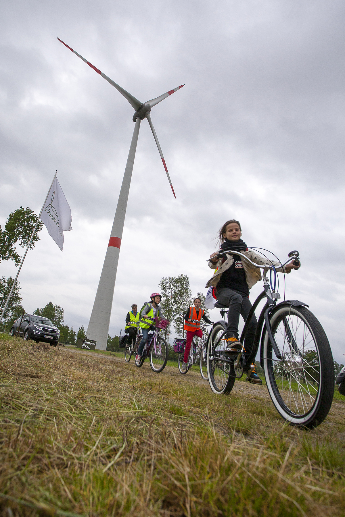 Kids ride their bikes to visit the turbine