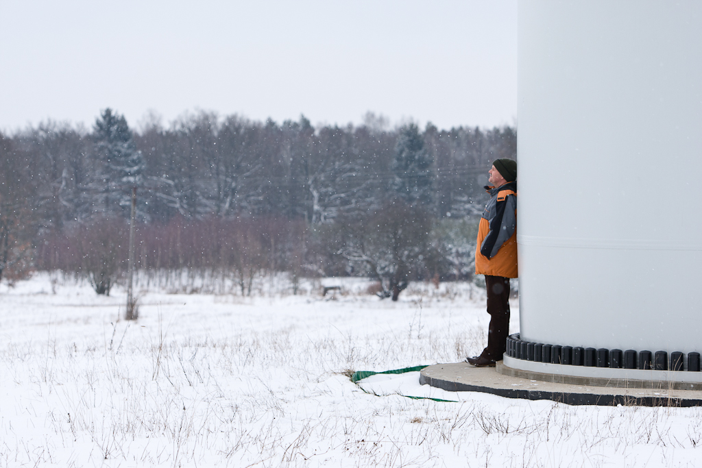 MirosÅawa Horodiuk rests against a wind turbine on his farm.